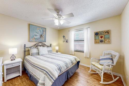 een slaapkamer met een bed en een plafondventilator bij Seahorse 122 in Gulf Shores