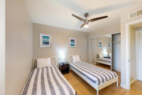 a bedroom with two beds and a ceiling fan at Golden Oasis, Unit #110 in Scottsdale
