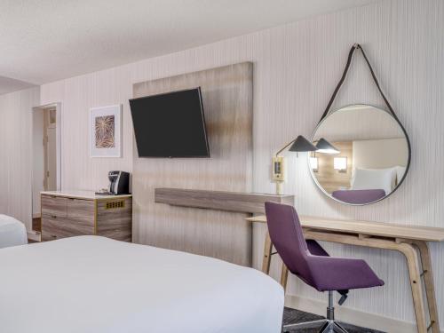 a hotel room with a bed and a mirror at Crowne Plaza Indianapolis-Airport by IHG in Indianapolis