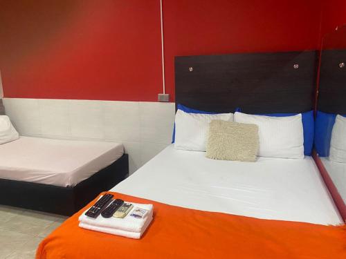 a hotel room with two beds with remotes on the bed at Hotel la Sierra Riohacha I in Ríohacha