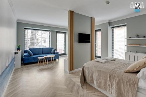 1 dormitorio con 1 cama azul y 1 sofá azul en MS Apartments Rest 3.0 en Sopot