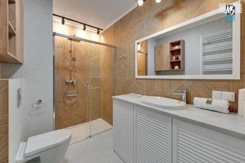 a bathroom with a shower and a toilet and a sink at MS Apartments Rest 3.0 in Sopot