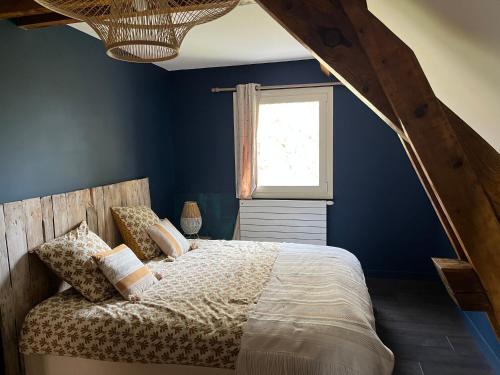 um quarto com uma cama com paredes azuis e uma janela em Le Zanzibar em Flavin