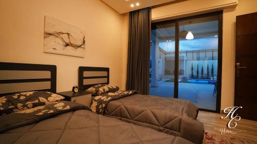 a bedroom with two beds and a balcony at Hero's Chalet - Deadsea in Al Rama