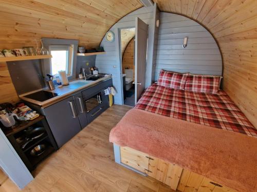 a small bedroom with a bed in a tiny house at Dalrigh Pod in Onich