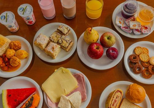 a table with plates of different types of food at UPG Hotel in Ubatuba