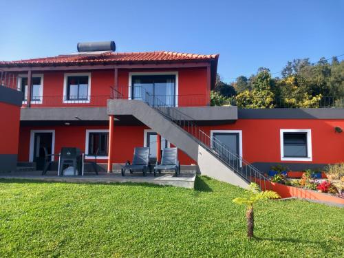 a red house with a staircase in front of it at Casa dos Avós Domingos & Matilde in Estreito da Calheta