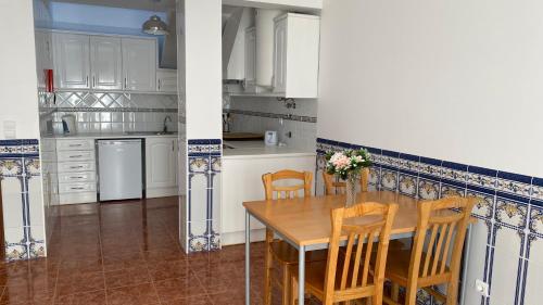 a kitchen with a wooden table and chairs in it at Ericeira Sand Beach F5 in Ericeira