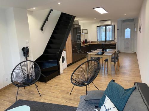 - un salon avec un escalier, une table et des chaises dans l'établissement « A la Mer des Caps », à Sangatte