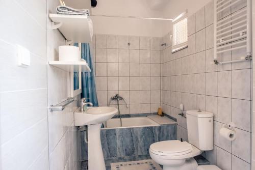 a bathroom with a toilet and a sink and a tub at Konstantina's Fairytale House in Kissamos