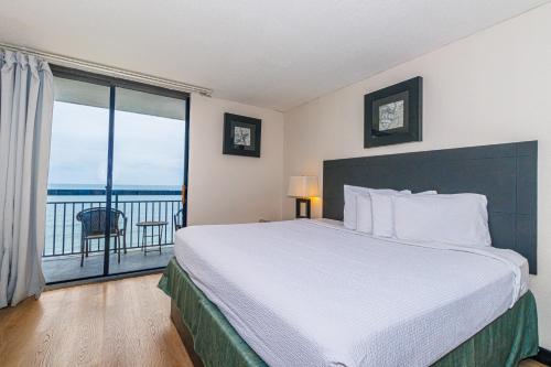 una camera con un grande letto e un balcone di Sun N Sand 607 a Myrtle Beach