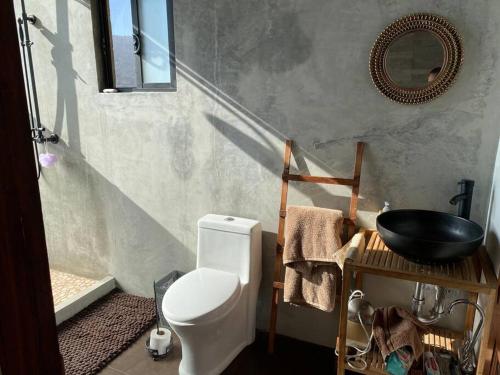 a bathroom with a white toilet and a sink at Cabaña Valzam 2 entre viñedos Rancho Tecate Resort in Tecate