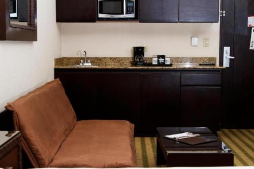 a living room with a couch and a kitchen at Rincon del Valle Hotel & Suites in San José