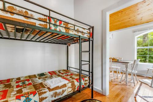 een slaapkamer met een stapelbed en een tafel bij Climbing Ivy Cabin in Newland