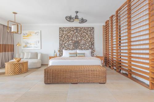 a bedroom with a king sized bed and a couch at Sanctuary Cap Cana, a Luxury Collection Resort, Dominican Republic, Adult All-Inclusive in Punta Cana