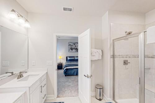 uma casa de banho branca com um chuveiro e um quarto em A Home Away from Home em North Myrtle Beach