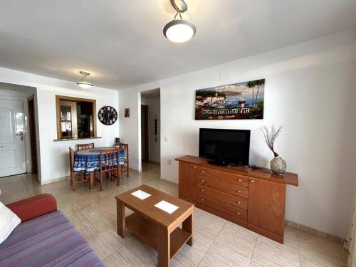 - un salon avec un canapé, une télévision et une table dans l'établissement Oropesa del Mar Inn, à Oropesa del Mar