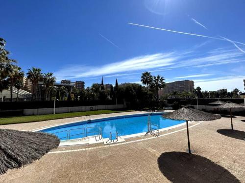 une grande piscine avec deux parasols dans l'établissement Oropesa del Mar Inn, à Oropesa del Mar