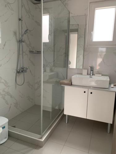 a white bathroom with a shower and a sink at Hayeks Villa in Daratso