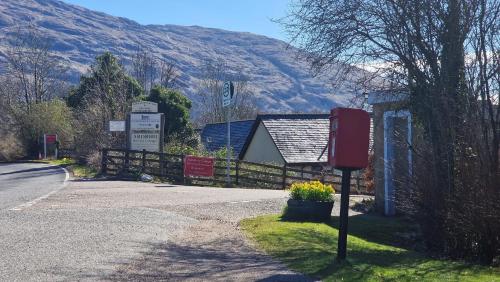a red mailbox on the side of a road at Dalrigh Pod in Onich