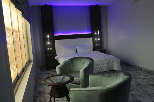 a bedroom with a bed and a chair and a table at Marina in Sohar