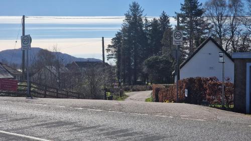 an empty street with a road with speed signs at Dalrigh Pod in Onich