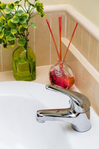 a sink with a faucet and a vase with flowers at Apartment Isla Canela Luxury in Huelva