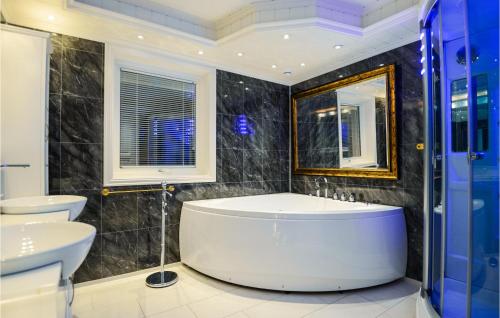 een badkamer met een bad, 2 wastafels en een spiegel bij Cozy Apartment In Fister With Wifi in Fister