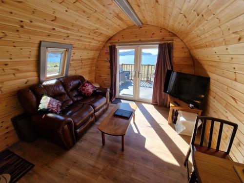 a living room with a couch and a tv at Dalrigh Pod in Onich