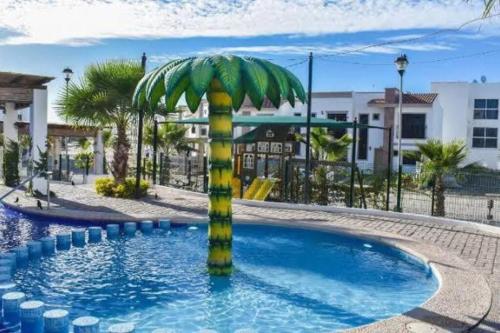 a palm tree in the middle of a pool at Departamento completo para 6 personas in Mazatlán