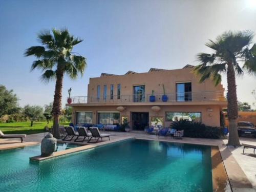 a house with a swimming pool in front of a house at Villa de rêve à Marrakech in Marrakesh