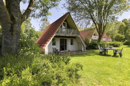 a house with a deck and a table in the yard at Luxe familie woning 'De Boskant' in Gramsbergen
