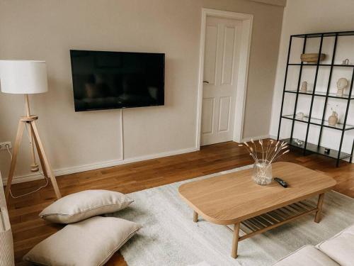 a living room with a coffee table and a flat screen tv at Zentrale 88qm mit Nähe zur Messe Essen! MA2L in Essen