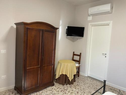 a room with a wooden cabinet and a table at Villa del Colle Bevagna in Bevagna