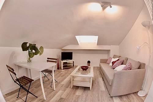 een woonkamer met een bank en een tafel bij Malaga Beach And Sun in Málaga