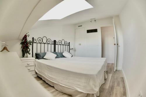 een slaapkamer met een groot wit bed en een spiegel bij Malaga Beach And Sun in Málaga