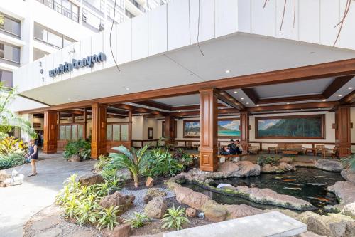 a building with a koi pond in front of it at Panoramic Mountain View Condo with Free Parking! in Honolulu