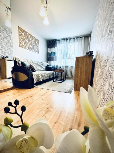 a living room with a couch and a wooden floor at Ogrodowy Apartament in Sandomierz