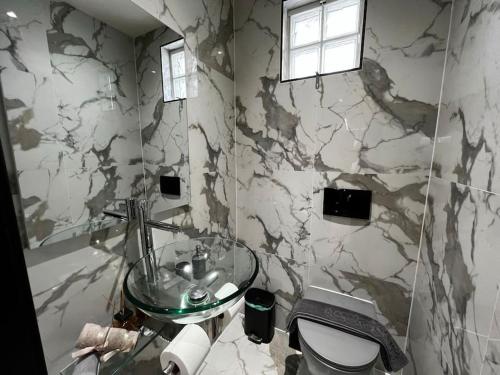 a bathroom with a sink and a marble wall at SoHo Loft in Alexandroupoli