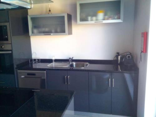 a kitchen with blue cabinets and a sink at Private Pool & House - Serenity Villa in Ancião