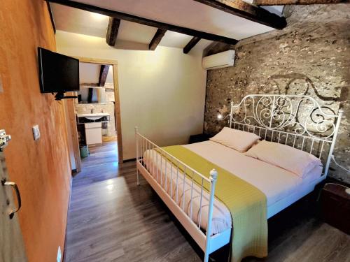 a bedroom with a bed and a stone wall at B&b 500' in Nogaredo