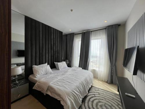 een slaapkamer met een groot bed en een groot raam bij Classic 2-bedroom condo in Lagos
