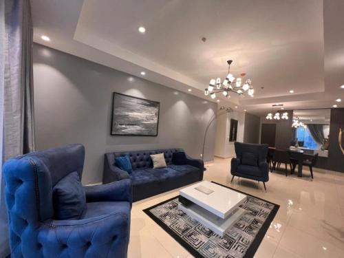 een woonkamer met blauwe banken en een eetkamer bij Classic 2-bedroom condo in Lagos