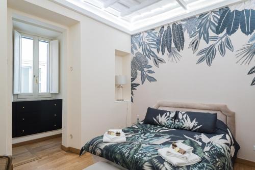 ein Schlafzimmer mit einem Bett mit einer tropischen Tapete in der Unterkunft Lupa Luxury Apartment in Rom