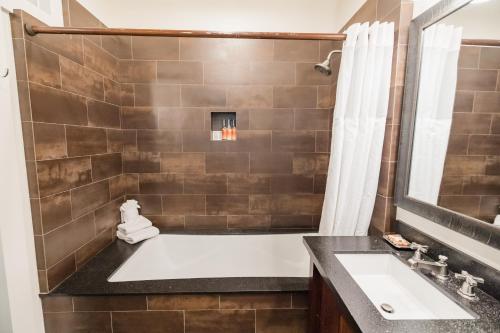 a bathroom with a tub and a sink and a shower at Lumeria Maui, Educational Retreat Center in Makawao