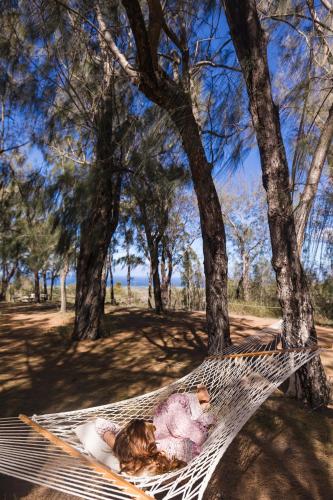 a little girl sleeping on a hammock in a tree at Lumeria Maui, Educational Retreat Center in Makawao