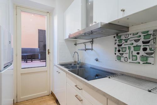 eine Küche mit einem Waschbecken und einem Fenster in der Unterkunft Lupa Luxury Apartment in Rom