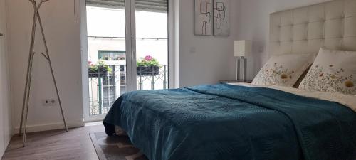 um quarto com uma cama grande e um cobertor azul em Castelo Terrace Apartement em Leiria