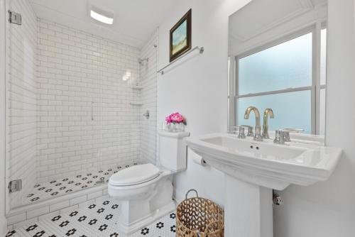 a white bathroom with a toilet and a sink at Beautiful Condo close to Saucy Brew Works - G in Sandusky