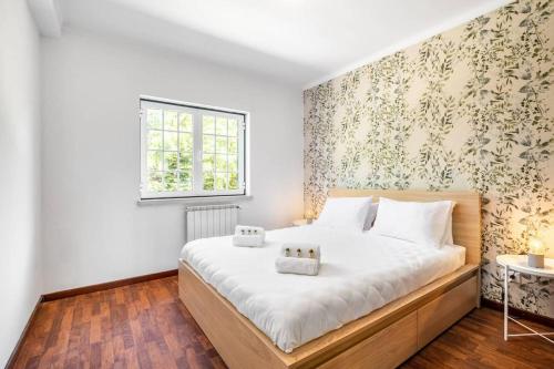 Un dormitorio con una gran cama blanca y una ventana en Villa Coral - Private Heated Pool & Hot tub en Famalicão
